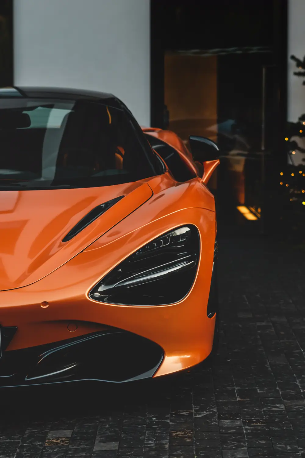 McLaren 720S laranja, farol em close